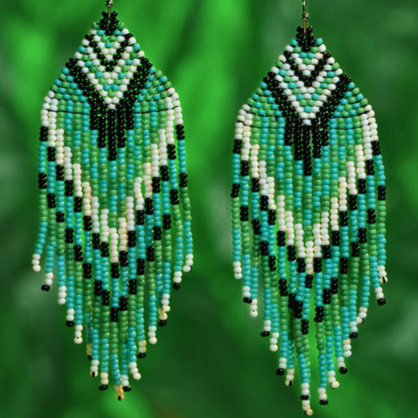 Close-up of green beaded fringe earrings with detailed handmade craftsmanship – artisan jewelry by Jenni and Janki